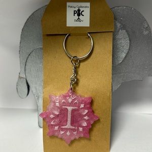 light pink key chains made from resin. The letter I sits in the middle